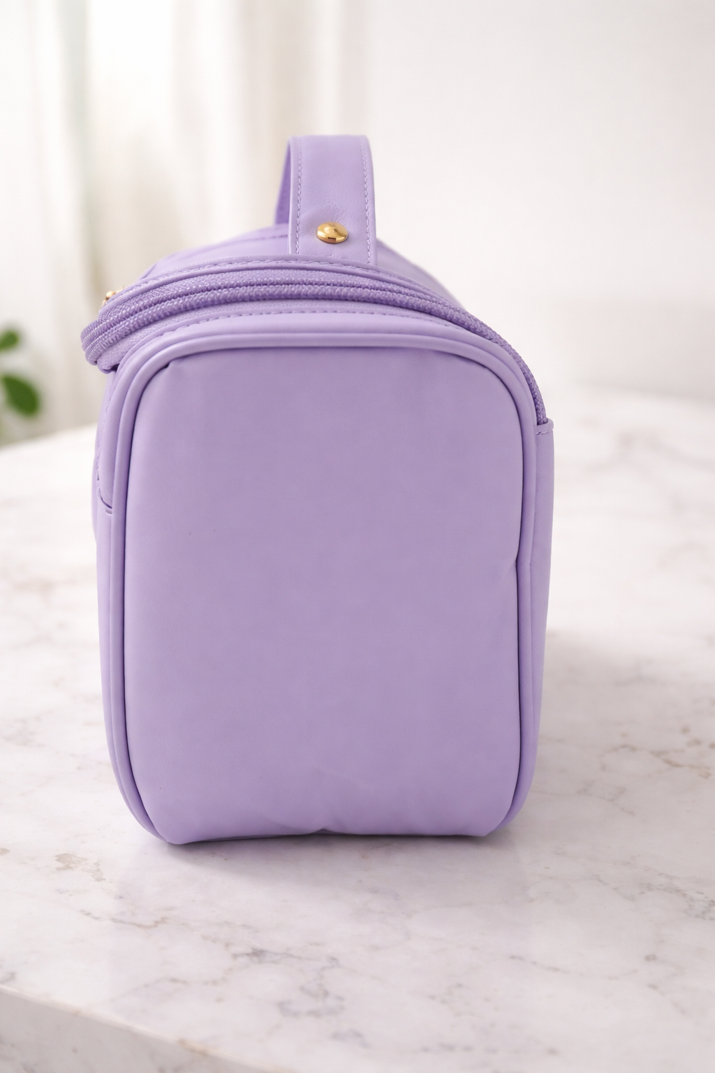 Lavender quilted beauty case on a marble surface