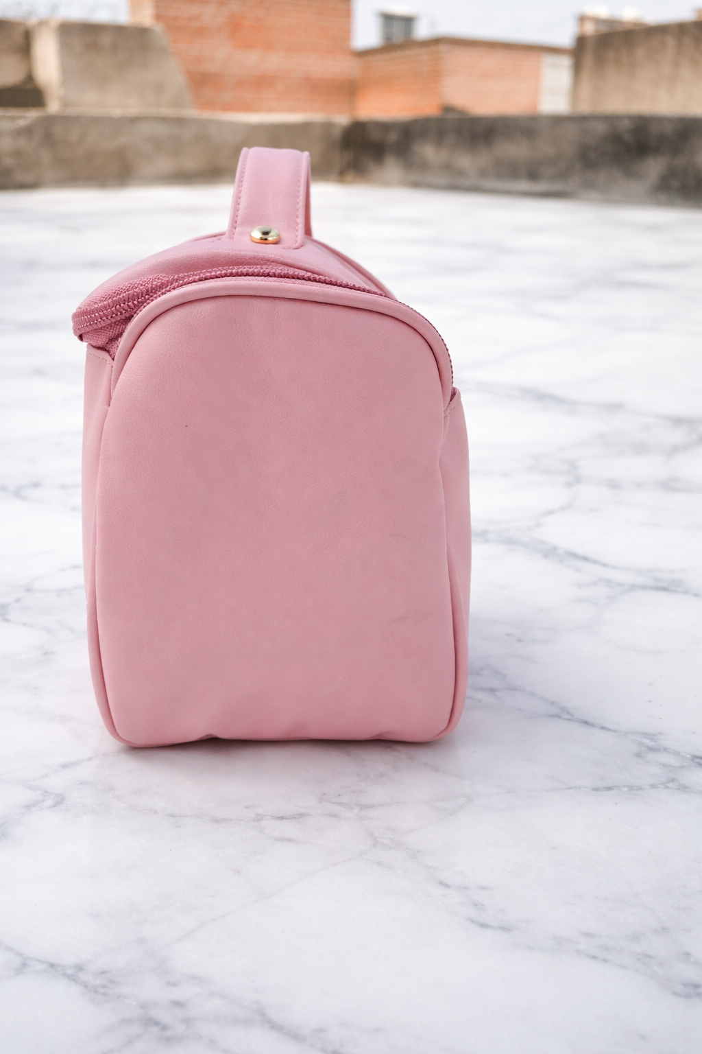 Pink quilted beauty case on a marble surface