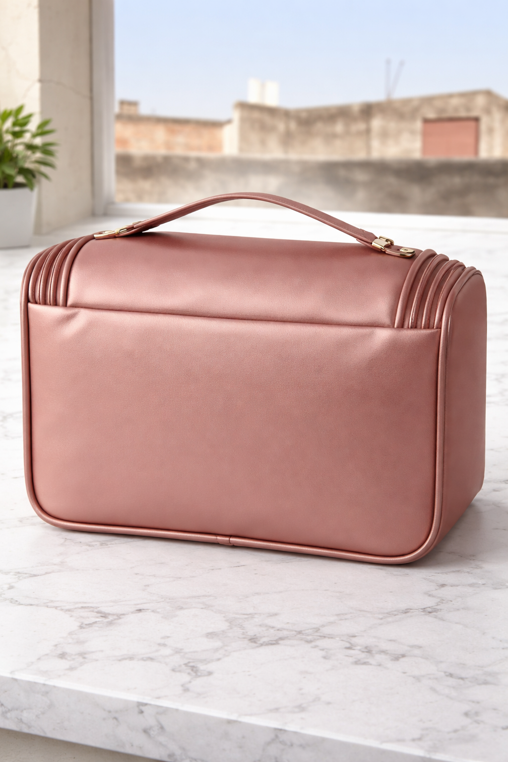 Rose gold quilted beauty case on a marble surface